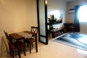 a dining room with a table and chairs and a television at 7F Majorca, Camella Manors Bacolod Condo in Bacolod
