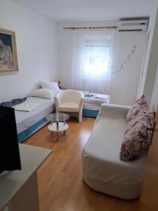 een woonkamer met een bank en een bed bij Apartments Jele II in Sveti Petar