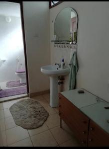a bathroom with a sink and a mirror at ZURI Homestay WIFI & Ocean BREEZE !! in Mombasa