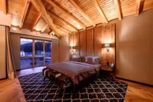 a bedroom with a large bed and a large window at Grand Hotel Therme in Banya