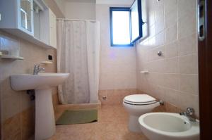 bagno con lavandino, servizi igienici e finestra di Piccolo Residence Gallipoli a Gallipoli
