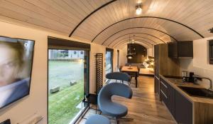a kitchen and living room in a house with a tv at LokoMotel-Waggon, Luxus Appartment im Eisenbahnwaggon in Stadtlohn
