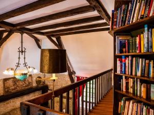 a room with bookshelves and a lamp and a staircase at LES TALOCHES in Tourtoirac