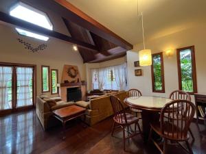 a living room with a table and a couch at Villa di Caserta by Capivari Lodge Home in Campos do Jordão