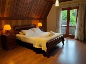 a bedroom with a bed with a teddy bear on it at Villa di Caserta by Capivari Lodge Home in Campos do Jordão