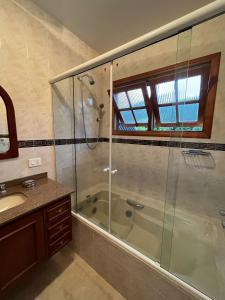 a bathroom with a shower and a tub and a sink at Villa di Caserta by Capivari Lodge Home in Campos do Jordão +63 photos