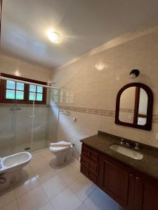 La salle de bains est pourvue de toilettes, d'un lavabo et d'une douche. dans l'établissement Villa di Caserta by Capivari Lodge Home, à Campos do Jordão