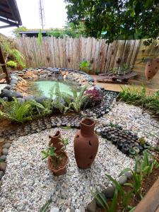 un pequeño estanque en un jardín con jarrones en el suelo en Beco Pousada Boutique, en Fernando de Noronha