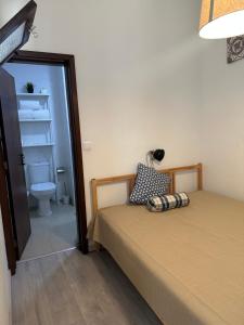 a bedroom with a bed and a bathroom with a toilet at Casa Valverde I in Amarante