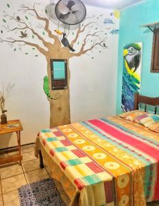 1 dormitorio con un árbol y TV en la pared en Hostel Terra Viva en Pipa