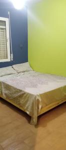 Bett in einem Zimmer mit einer blauen und grünen Wand in der Unterkunft dalas in Saidia 