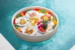 una mesa de alimentos en un recipiente en el agua en Villa Mia Seminyak - Boutique Villas en Seminyak