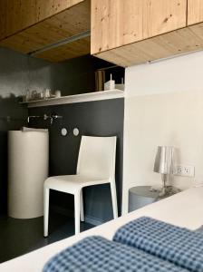 - une chambre avec une chaise blanche et un lit dans l'établissement Le4bergheim Chambre d'hôtes, à Bergheim