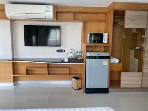 a kitchen with a refrigerator and a tv at L18 residence in Ban Zong Katiam