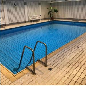 a large swimming pool with blue water in a building at Ferienwohnung Hooge 30 in Wyk auf Föhr
