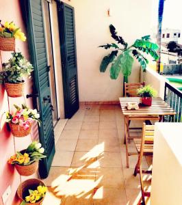 a balcony with a table and potted plants and a door at HOLLY CASA VACANZE TORRE DELL'ORSO in Torre dell'Orso