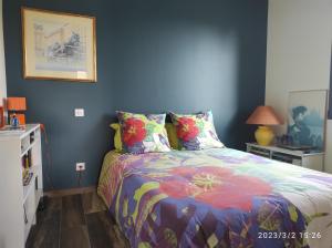 1 dormitorio con 1 cama con un edredón colorido en Proche Circuit, en Mulsanne