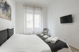 a bedroom with a large white bed with towels on it at Casa Flaminia in Rome