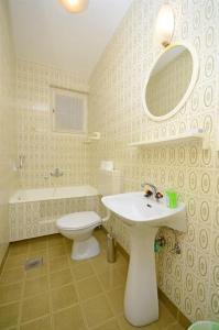 La salle de bains est pourvue d'un lavabo, de toilettes et d'un miroir. dans l'établissement Lui, à Gradac