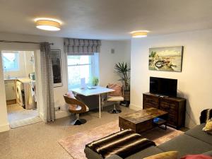 una sala de estar con un sofá y una mesa en Seaside Flat With Sunny Garden., en Brighton & Hove