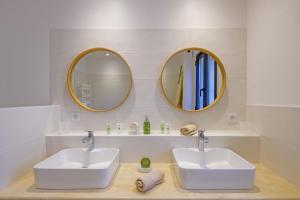 two sinks in a bathroom with two mirrors at La Petite Maussanaise in Maussane-les-Alpilles