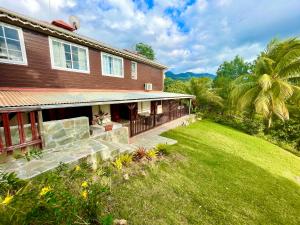 a house with a yard and a lawn at LES GITES DE LA RESERVE in Bouillante
