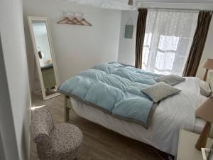 オンフルールにあるLes Apparts du Phareのベッドルーム1室(ベッド1台、椅子、窓付)