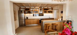 La cuisine est équipée d'armoires en bois et d'un réfrigérateur en acier inoxydable. dans l'établissement VeneTerra - Refined Elegance in a 4-Bed Kea Villa, à Koundouros