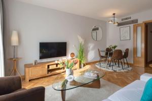 salon z telewizorem i stołem w obiekcie Vivienda con zona de trabajo, piscina y parking w Madrycie
