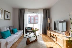 salon z białą kanapą i telewizorem w obiekcie Vivienda con zona de trabajo, piscina y parking w Madrycie