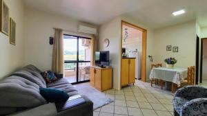 a living room with a couch and a tv and a kitchen at Mirante das Aguas de Piratuba in Piratuba