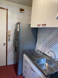 una cucina con lavandino e frigorifero di DEPARTAMENTO 2 EN PLENO CENTRO DE PUERTO MONTT a Puerto Montt