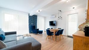 een woonkamer met een bank en een tafel bij Apartamenty EverySky - Dom Reymonta 9 in Karpacz