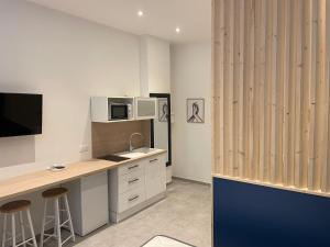 a kitchen with a desk and a counter with a microwave at Les Bulles de Mona "Le 149" -PROXIMITE GARE DE LYON- in Lyon
