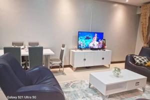 a living room with a flat screen tv on a wall at Joy Pristine Nairobi in Silverstone, 2 bed&bathroom, swimming pool, free parking in Nairobi