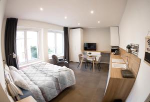 a bedroom with a bed and a desk and a kitchen at La Residenza Isabella in Milan
