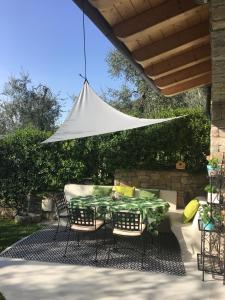 een tafel en stoelen op een patio met een witte parasol bij Patty's Lemonhouse in Limone sul Garda