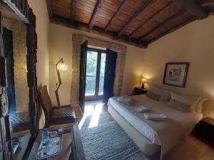 a bedroom with a large bed and a window at Quinta do Caneiro in Geres