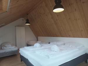 a bedroom with a bed with white sheets and towels at Ruim appartement in prachtige fiets-wandelomgeving in Abcoude
