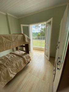 a bedroom with a bunk bed and a sliding glass door at Aluga-se casa para Temporada in Águas de Lindoia