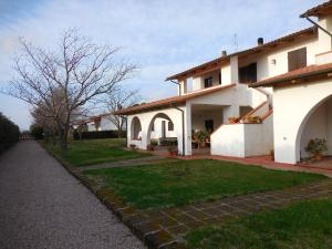 ein großes weißes Haus mit einem Rasenhof in der Unterkunft Azienda Il Tizzano in Albinia