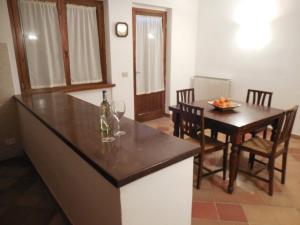 eine Küche und ein Esszimmer mit einem Tisch und Weingläsern in der Unterkunft Azienda Il Tizzano in Albinia