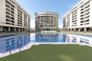 una gran piscina con 2 edificios altos en Veramar Beach Apartment, en Valencia