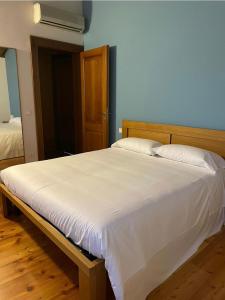 1 dormitorio con 1 cama blanca grande y cabecero de madera en Bed and Breakfast Ca’ Pisani, en Stra