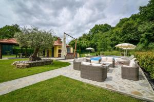 eine Terrasse mit Korbmöbeln und einem Pool in der Unterkunft Villa Ariola in Villafranca in Lunigiana