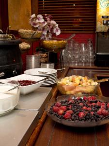 a table topped with bowls of fruit and pies at Kauppahotelli in Lahti