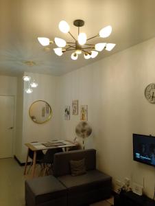 een woonkamer met een plafondventilator en een tafel bij Traveller Residence by Celandine in Manilla