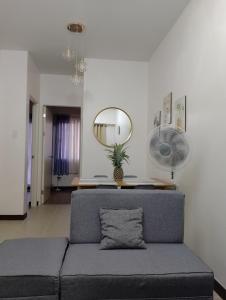 een woonkamer met een blauwe bank en een spiegel bij Traveller Residence by Celandine in Manilla