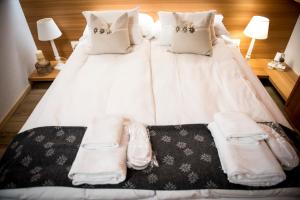 a large white bed with white blankets and pillows at Chalet Bambi in Rabbi