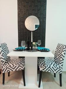 a white table with two chairs and a mirror at Apartman SILVER in Sremska Mitrovica